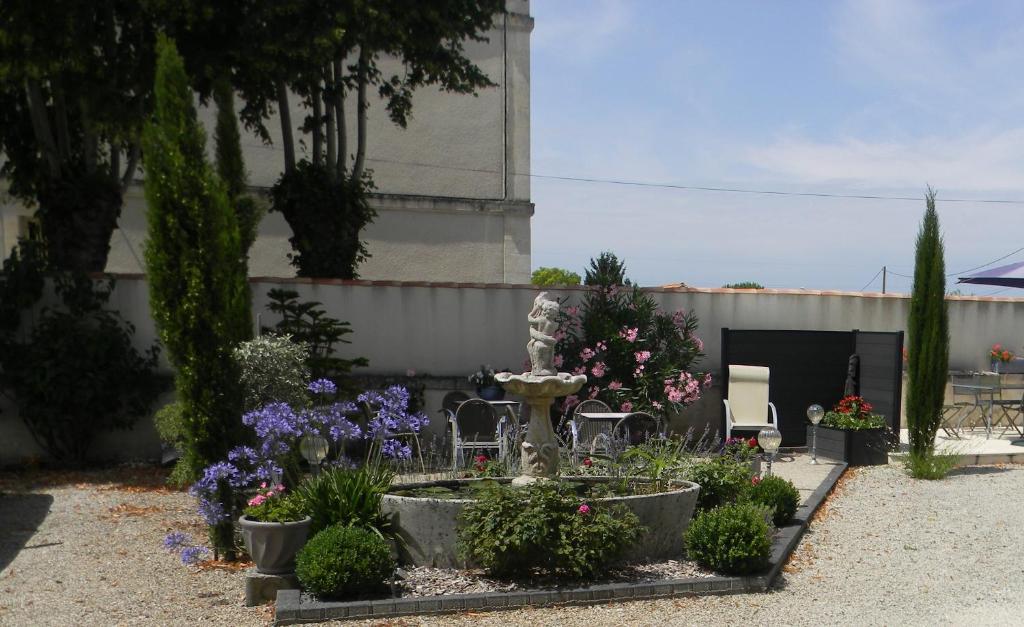 a garden with flowers and plants in front of a building at Le Logis d&#39;ANTIGNY in Val-du-Mignon