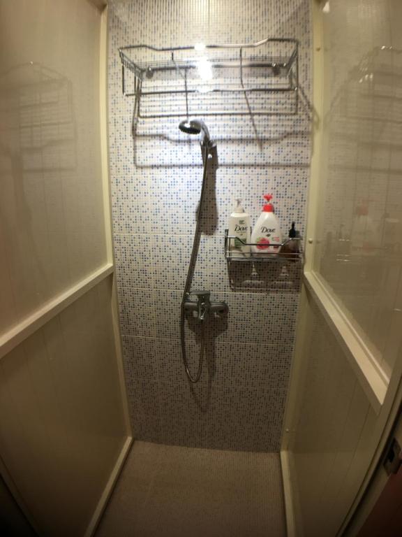 a shower in a bathroom with a tiled wall at Corner Inn九份住宿I 小角落民宿I 機車租借I日夜間導覽 in Jiufen