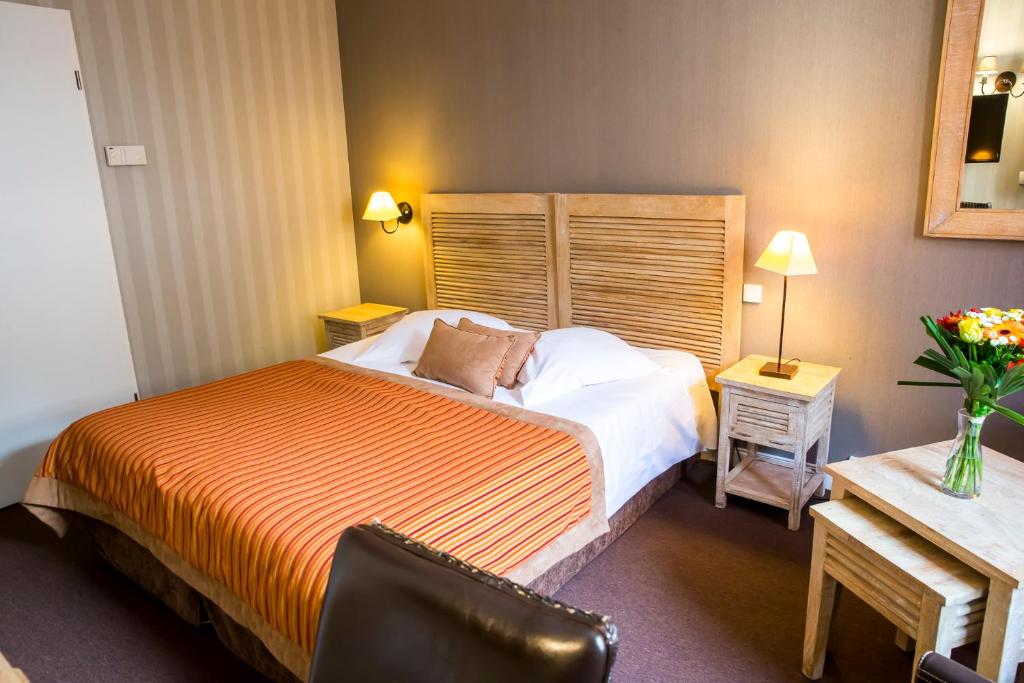 a bedroom with a bed and a desk with a chair at Almoria Hôtel & SPA in Deauville