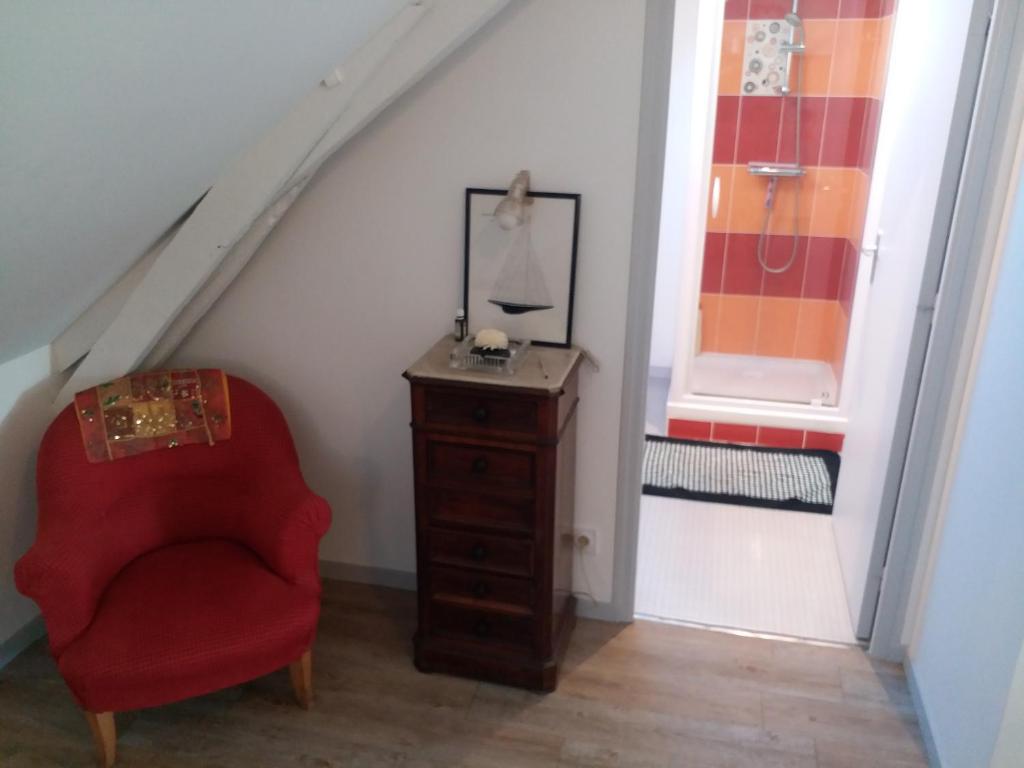 a red chair and a dresser in a room at Appartements T2 Proche de Rennes in Chantepie