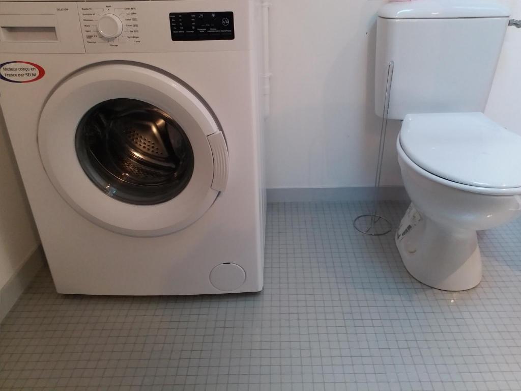 a washing machine in a bathroom with a toilet at Appartements T2 Proche de Rennes in Chantepie
