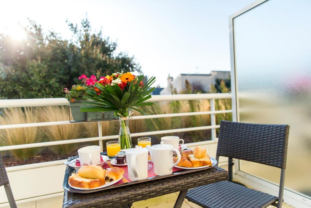 a tray of breakfast food on a table on a balcony at Almoria Hôtel & SPA in Deauville