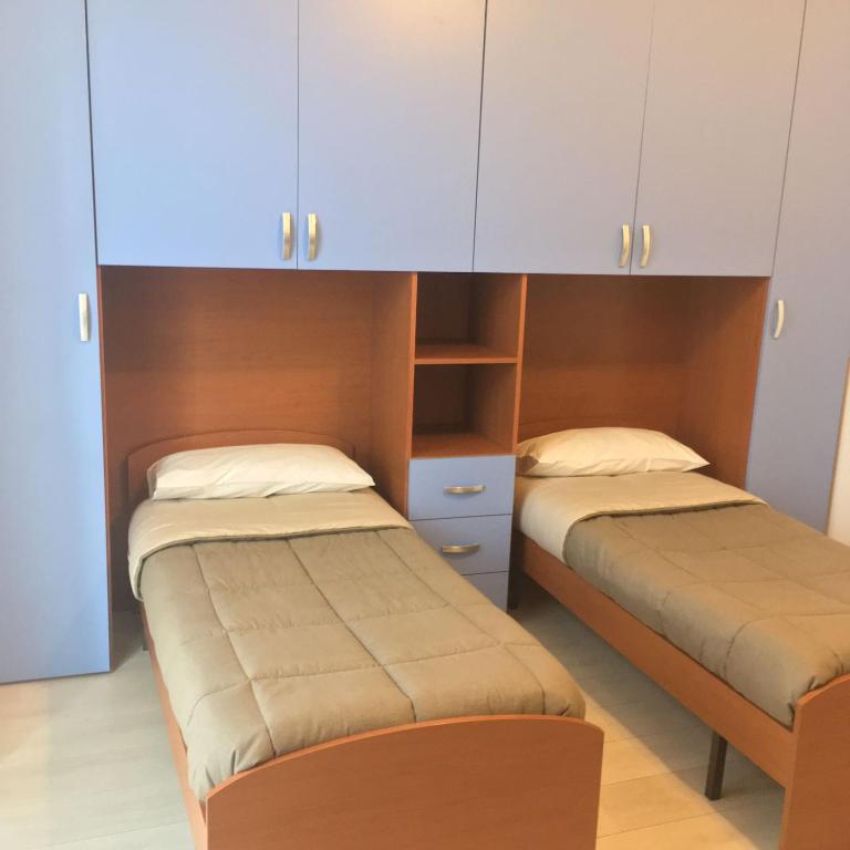 una camera con due letti e un armadio di Parea House 2 a Milano