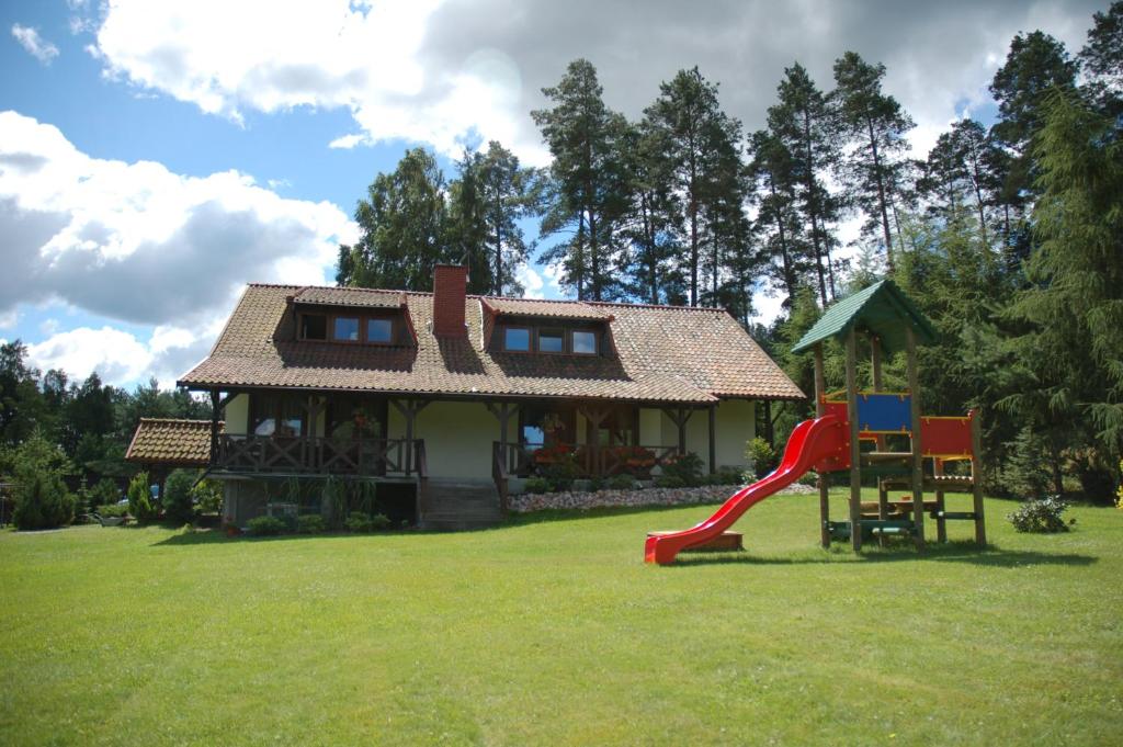 a small house with a slide and a playground at Ostoja Spychowo in Spychowo
