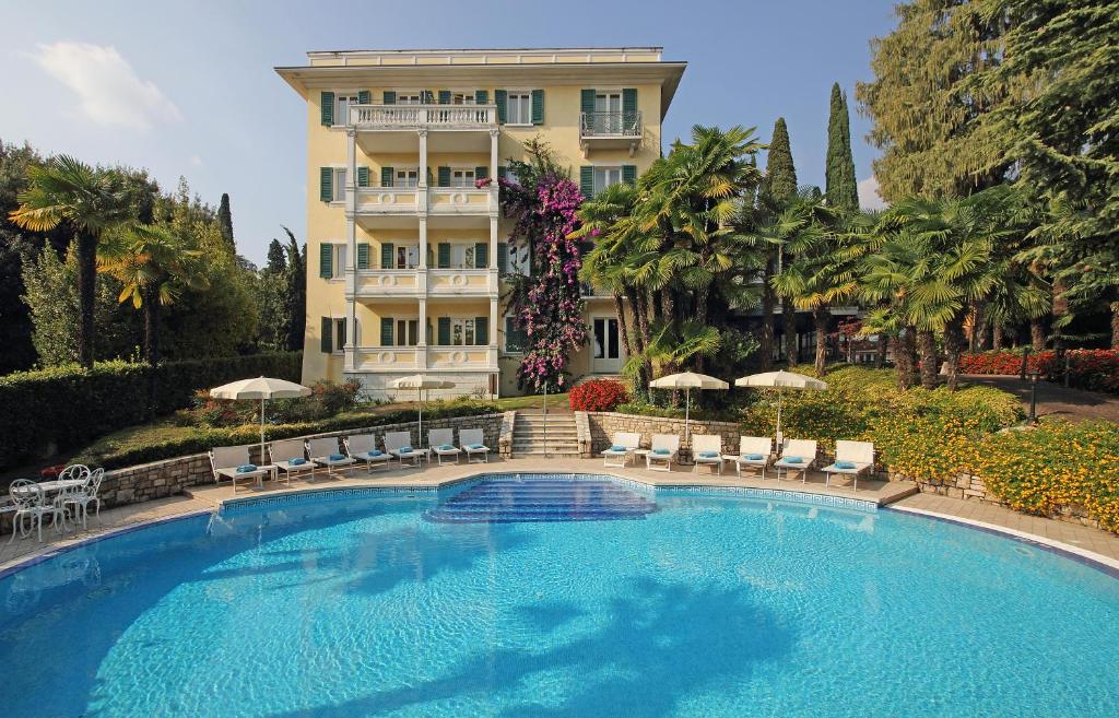 una gran piscina frente a un edificio en Villa Sofia Hotel, en Gardone Riviera