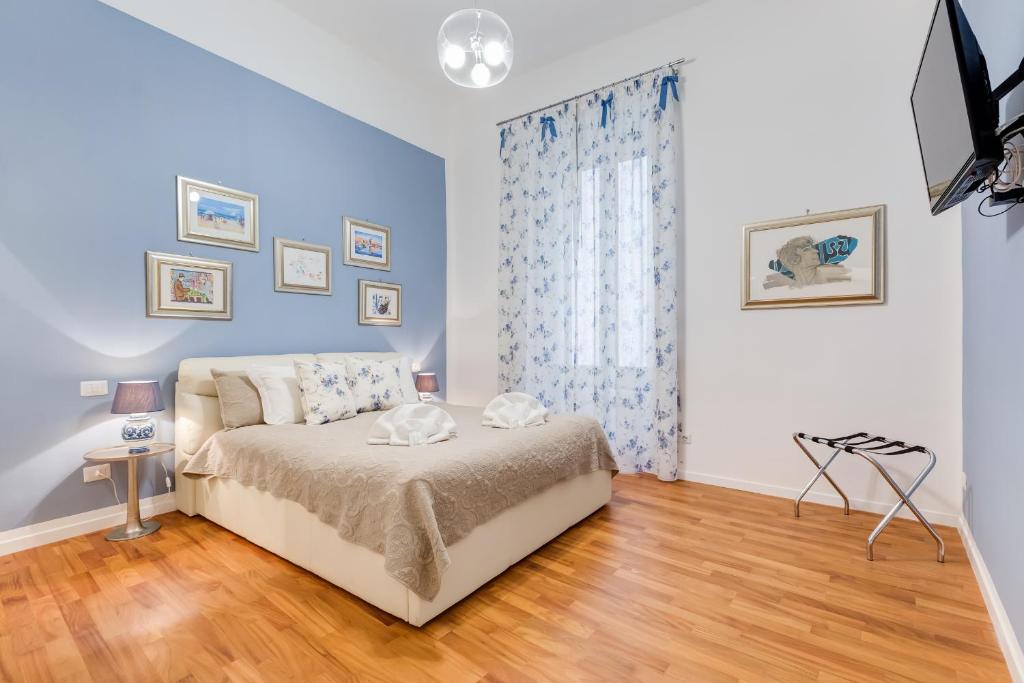 ローマにあるValadier Apartmentのベッドルーム1室(青い壁とウッドフロアのベッド1台付)