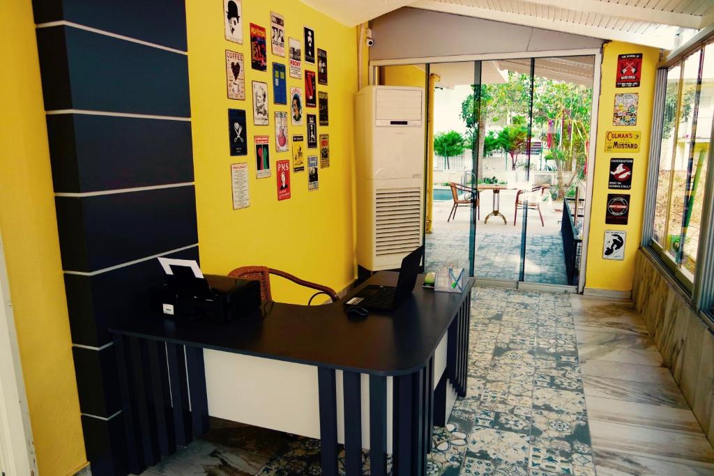 an office with a black desk and yellow walls at Ale Park Hotel Apartments in Antalya
