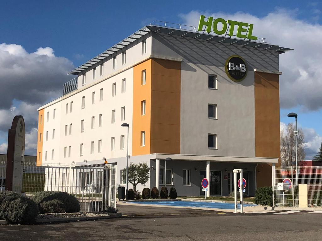 um edifício de hotel com uma placa de hotel em cima em B&B HOTEL Lyon Eurexpo Chassieu em Chassieu