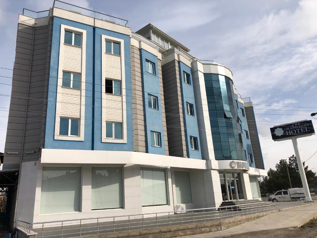 een blauw gebouw met een bord ervoor bij Grand Dost Hotel in Osmancık