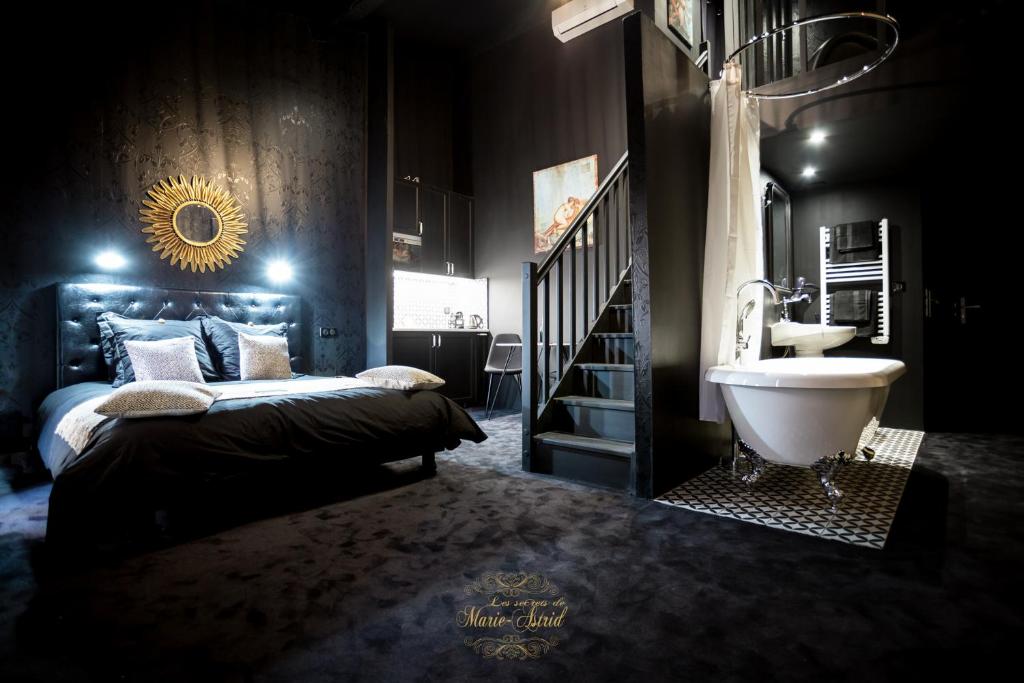 ボルドーにあるLes Secrets de Marie-Astrid, Suite Love Roomのベッドルーム1室(ベッド1台、バスタブ、シンク付)