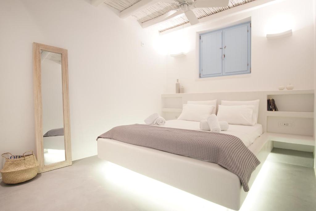 クフォニシアにあるPyrthea Housesの白いベッドルーム(大型ベッド1台、鏡付)