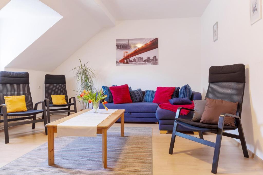 uma sala de estar com um sofá azul e duas cadeiras em Apartment Breite Str. 83 em Witten