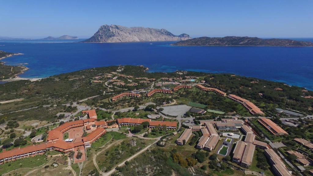 an aerial view of a building on a hill next to the water at Residence Porto Coda Cavallo in San Teodoro