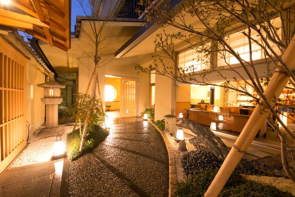 京都市にある松井本館の木々と灯りが灯る中庭のある建物