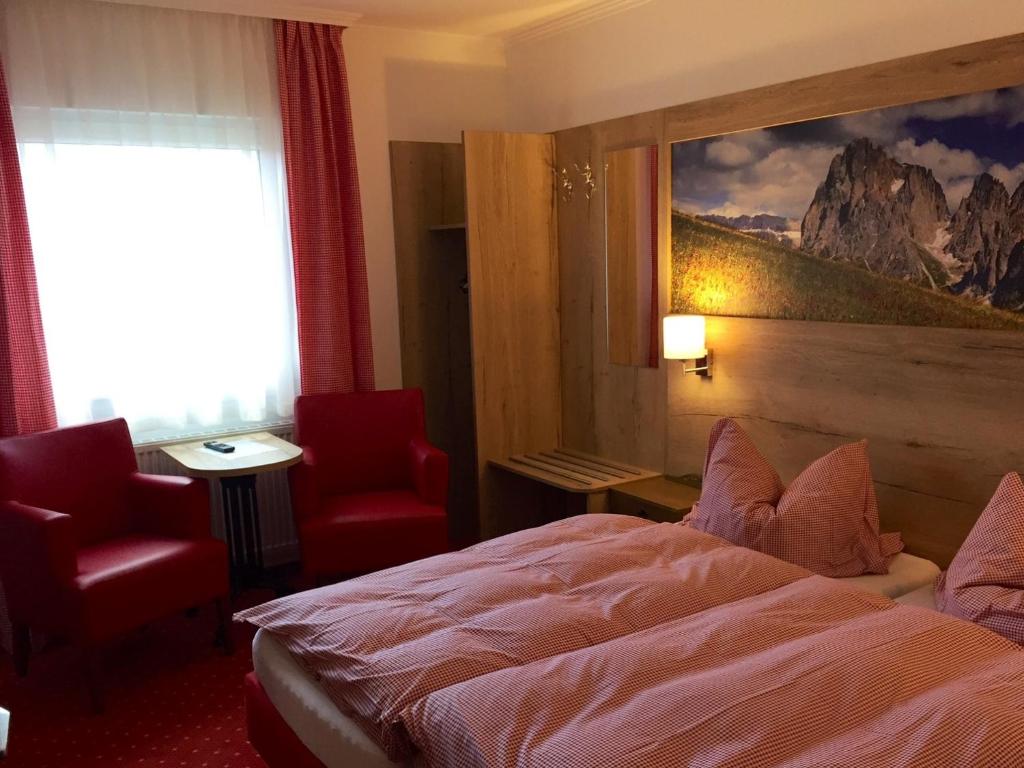 a hotel room with a bed and a painting on the wall at Hotel Peiler Garni in Iserlohn