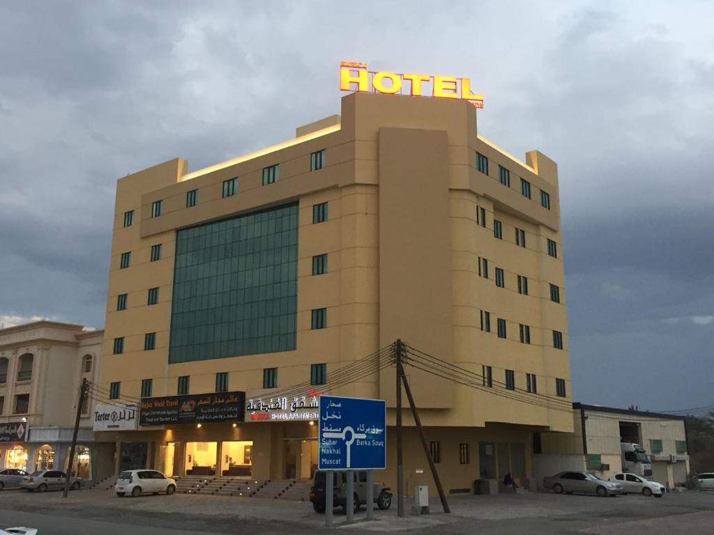 a hotel with a hotel sign on top of it at Barka Hotel Apartment in Samhān