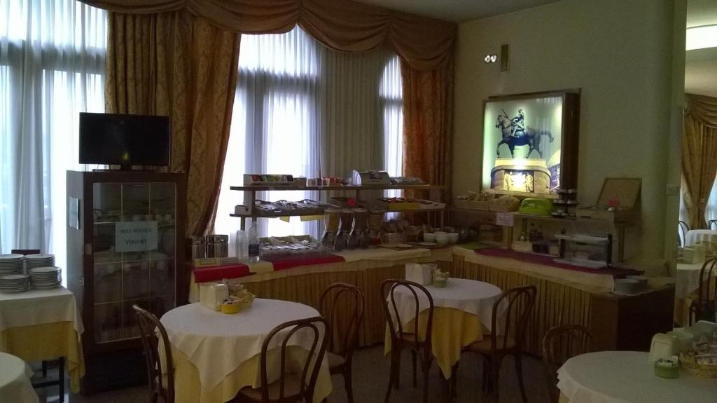 パドヴァにあるホテル ドナテッロのテーブルと椅子が備わるレストラン