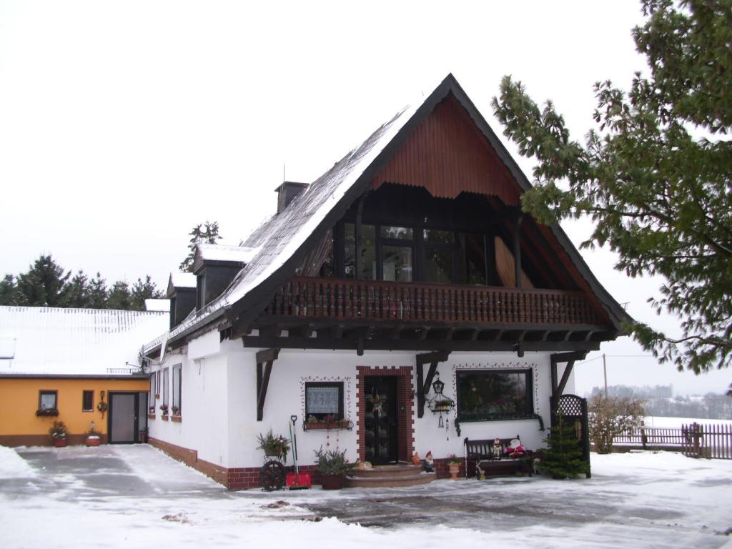 ein großes weißes Haus mit einem Gameradach in der Unterkunft Herzfenner Hof in Auw