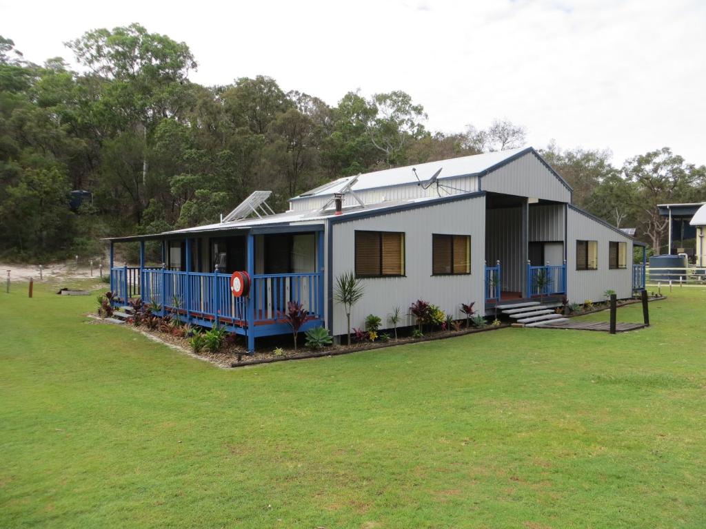 a small white house with a large yard at Orchid Beach Retreat Orchid Beach Fraser Island in K'gari Island (Fraser Island)