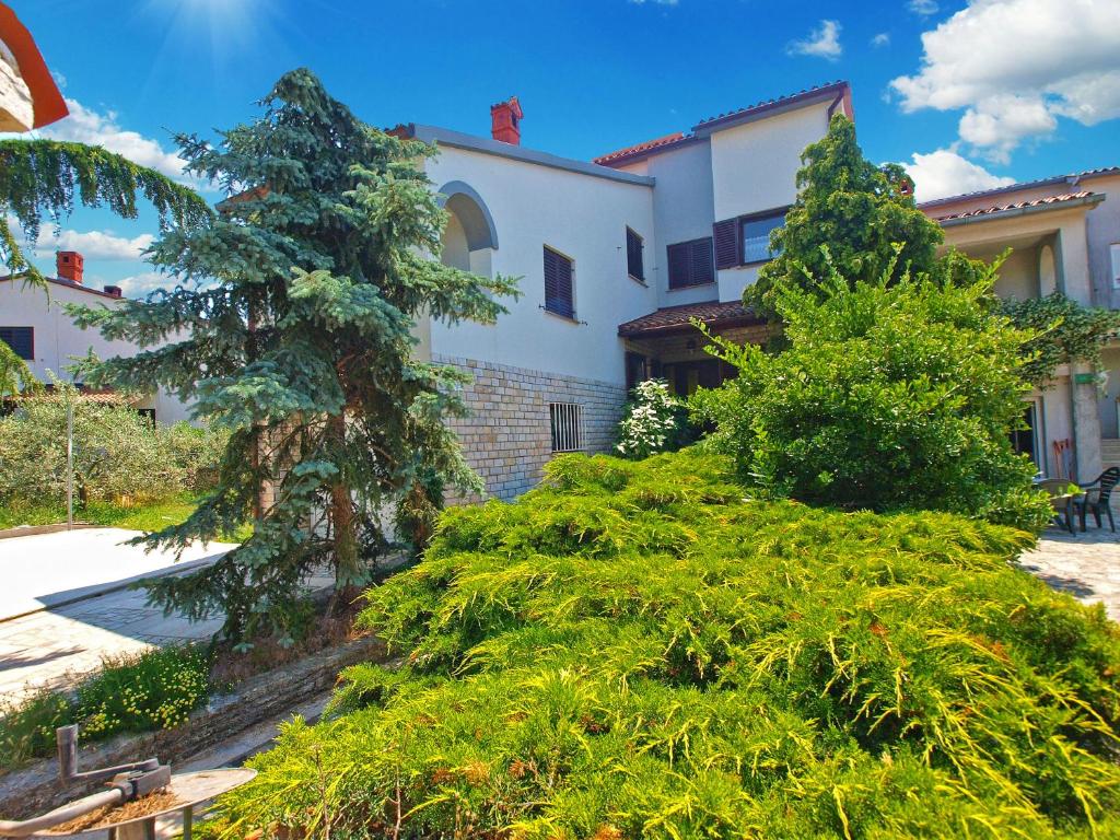 una casa con árboles y arbustos delante de ella en Apartments Adrijana 736, en Štinjan