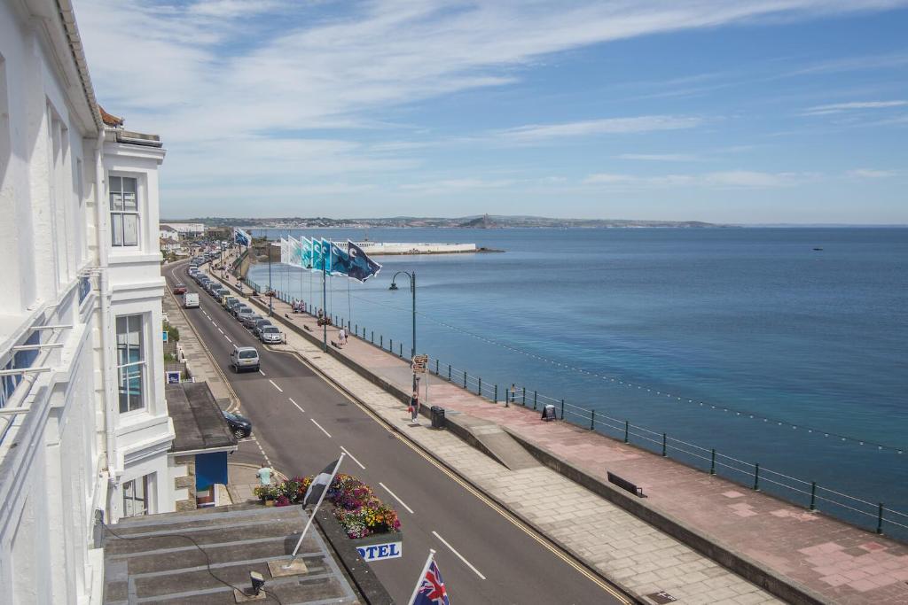 a view of a street and the ocean from a building at The Queens Hotel in Penzance