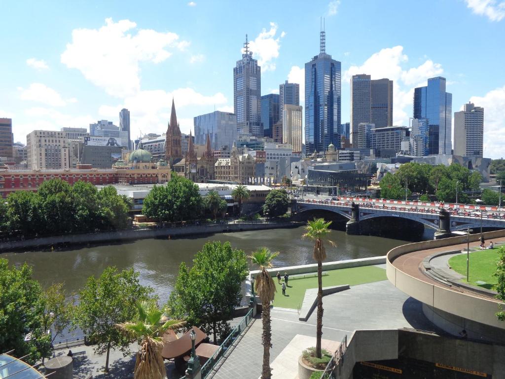 a view of a city with a river and a bridge at PrivateStudio in Quay West Building in Melbourne
