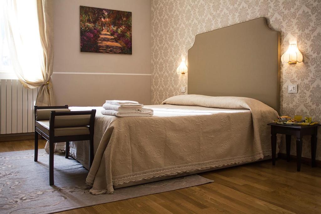 una camera da letto con un letto con specchio e una sedia di Hotel Navy a Livorno