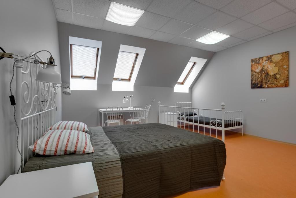 sypialnia z łóżkiem w pokoju z oknami w obiekcie Liberty w Rydze