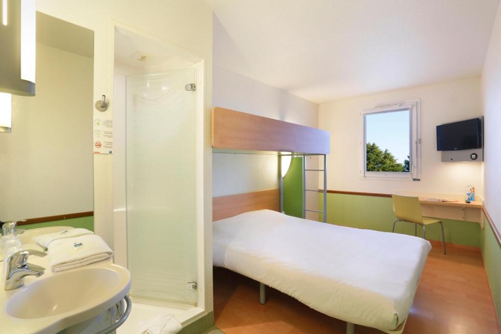 a hospital room with a bed and a sink at Hotel Ibis Budget Cosne Sur Loire in Cosne-Cours-sur-Loire