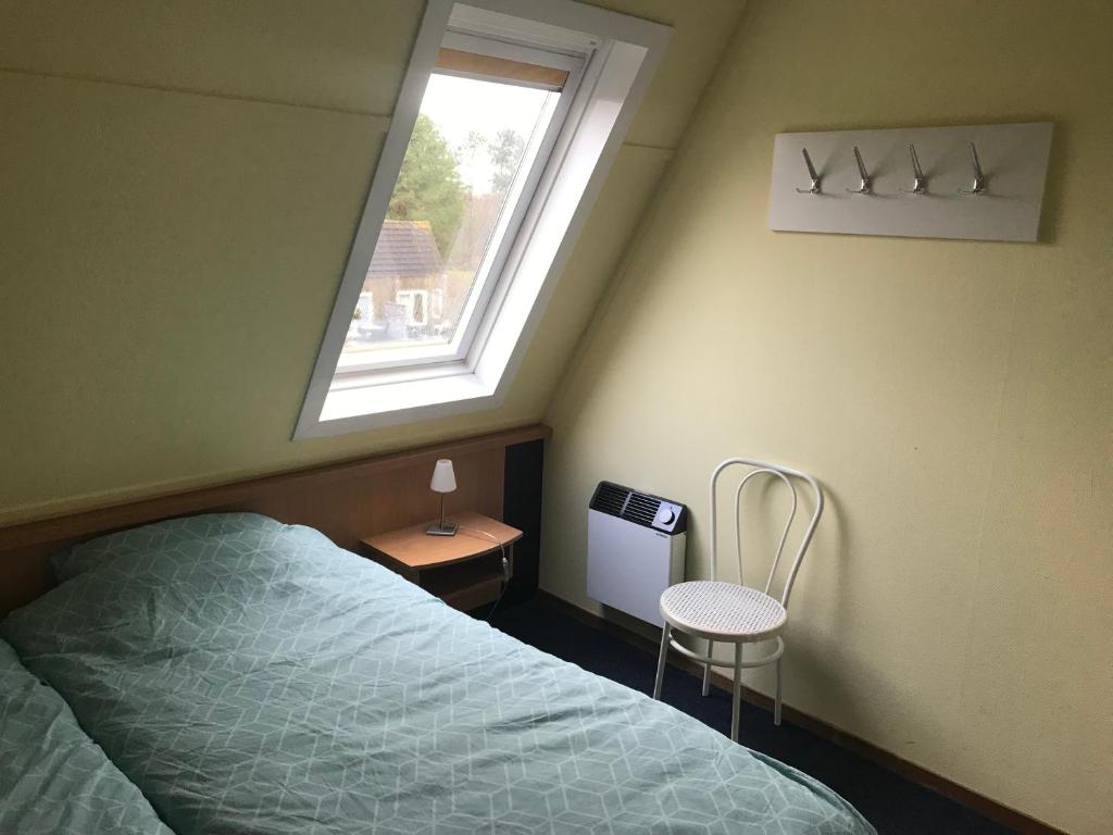 Schlafzimmer mit einem Bett und einem Fenster in der Unterkunft Amelander Kaap 35 in Hollum