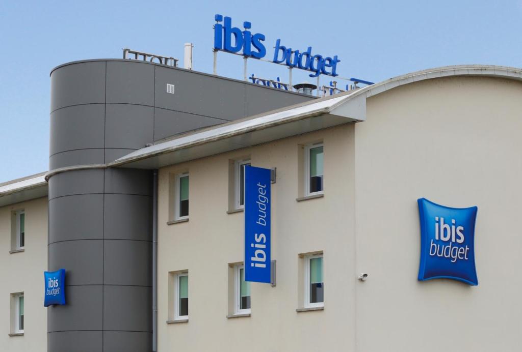 a building with blue signs on the top of it at Hotel Ibis Budget Cosne Sur Loire in Cosne-Cours-sur-Loire
