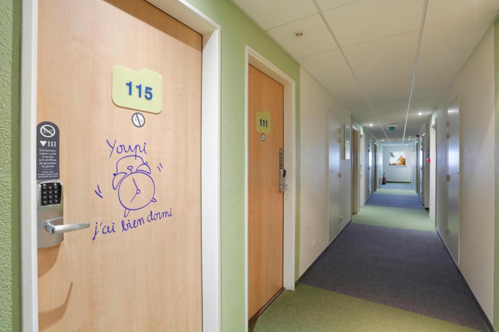a hallway in a hospital with a sign on a door at Hotel Ibis Budget Cosne Sur Loire in Cosne-Cours-sur-Loire