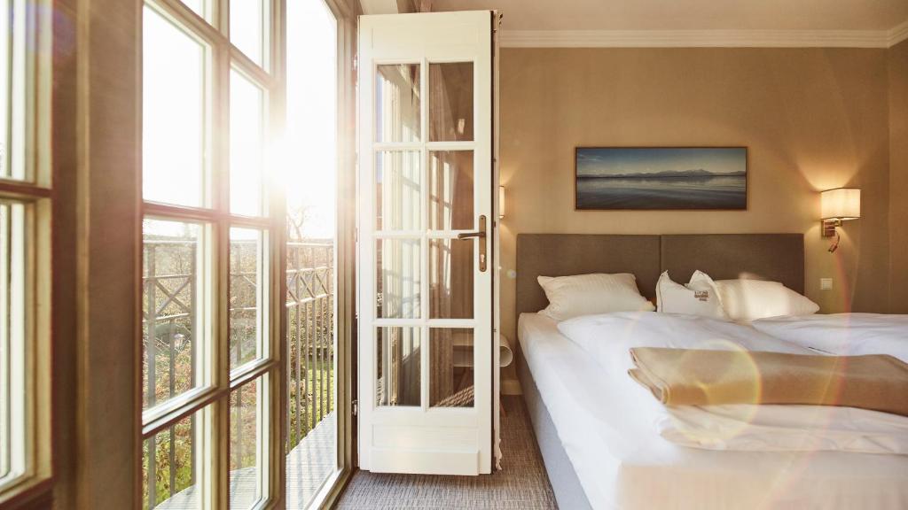 a bedroom with a bed and a large window at Hotel Gutsgasthof Stangl in Neufarn