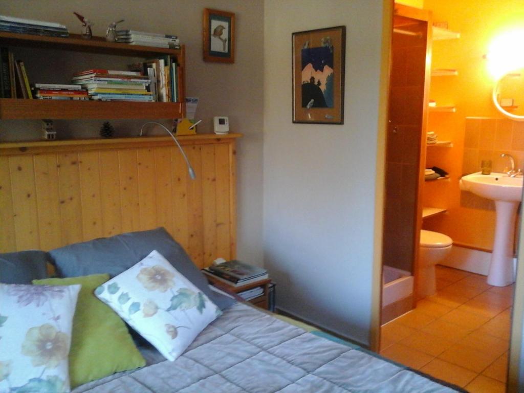 a room with a couch and a bathroom with a sink at Chambre d'Hôte ROMARICA in Saint-Sigismond