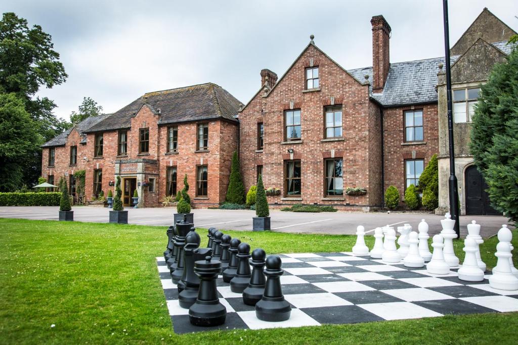 un tablero de ajedrez en el césped frente a un edificio en Hatherley Manor Hotel & Spa, en Gloucester