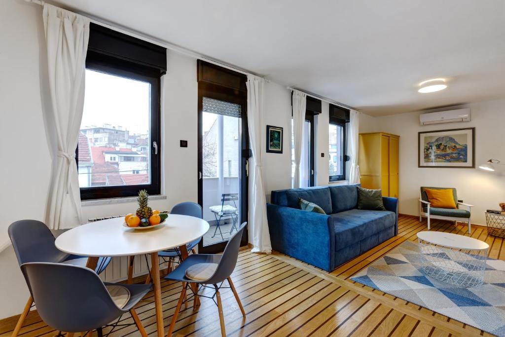 uma sala de estar com uma mesa e cadeiras e um sofá em Apartments Viola em Zagreb