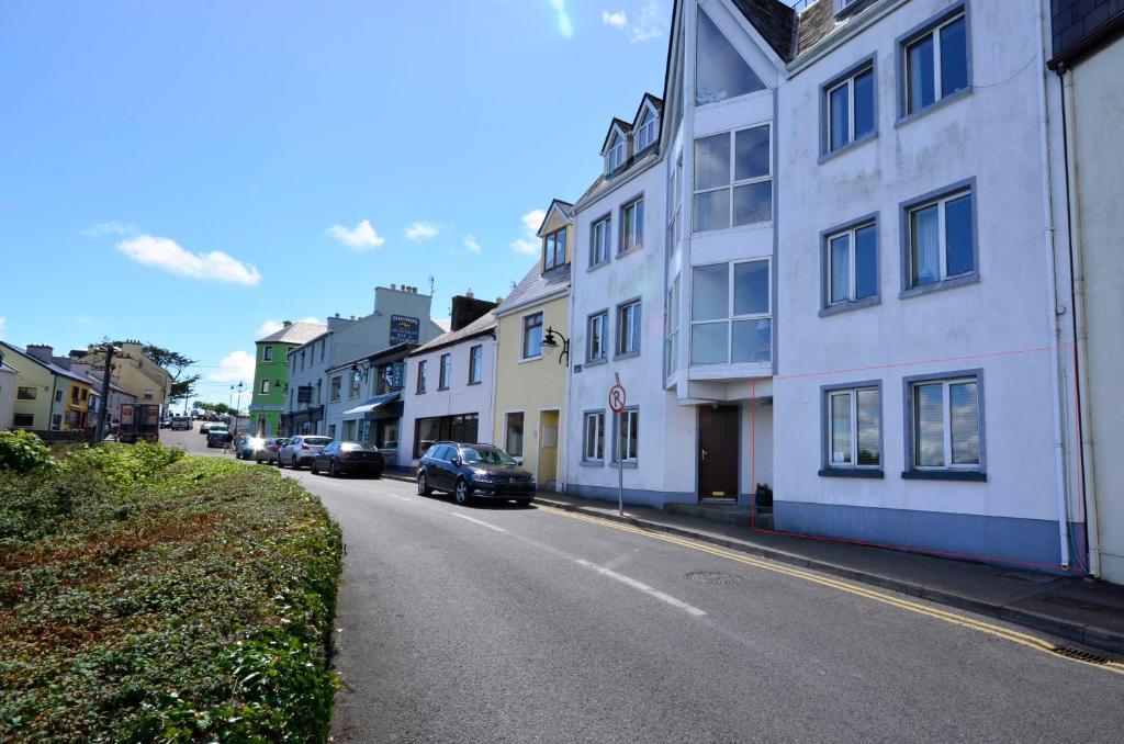 a street with buildings and a car parked on the road at Apartment 235 Roundstone in Roundstone