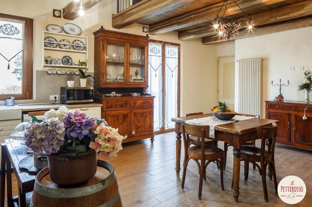 uma cozinha com uma mesa de madeira e uma sala de jantar em Il Pettirosso em Santarcangelo di Romagna