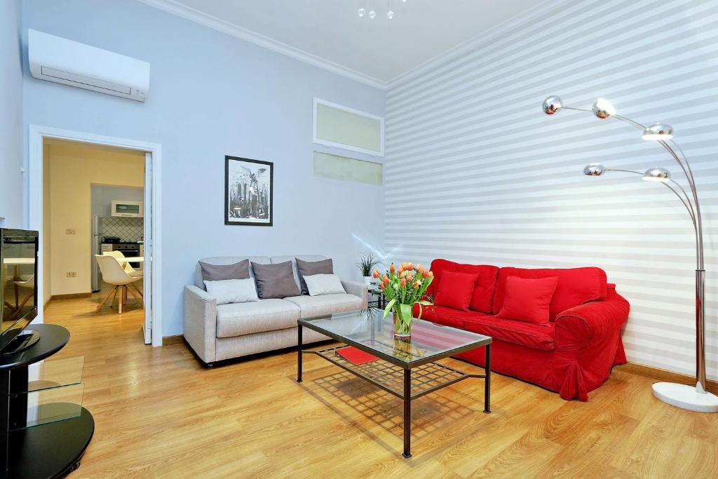 sala de estar con sofá rojo y mesa en Cozy Tritone - My Extra Home, en Roma