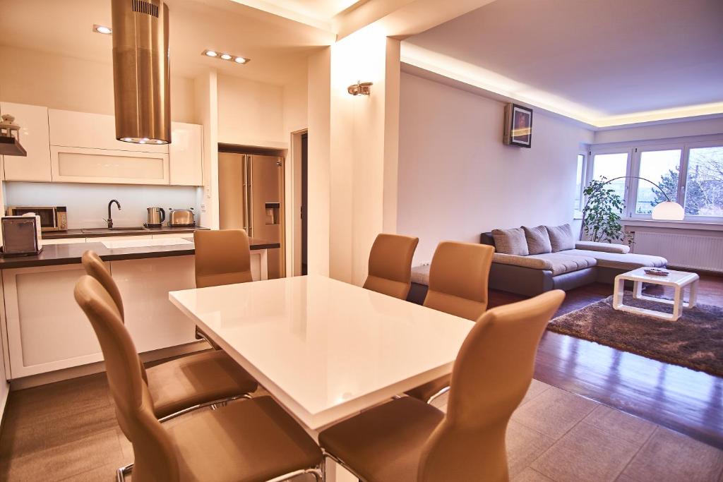 a kitchen and living room with a white table and chairs at Alpha Residence in Budapest