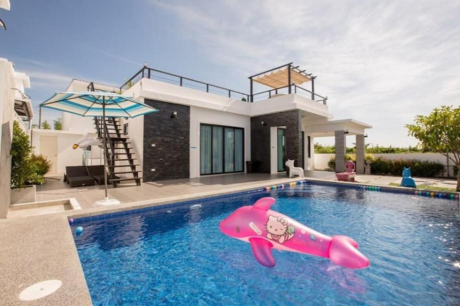 a house with a pink float in a swimming pool at @CHAIN Pool Villa in Hua Hin