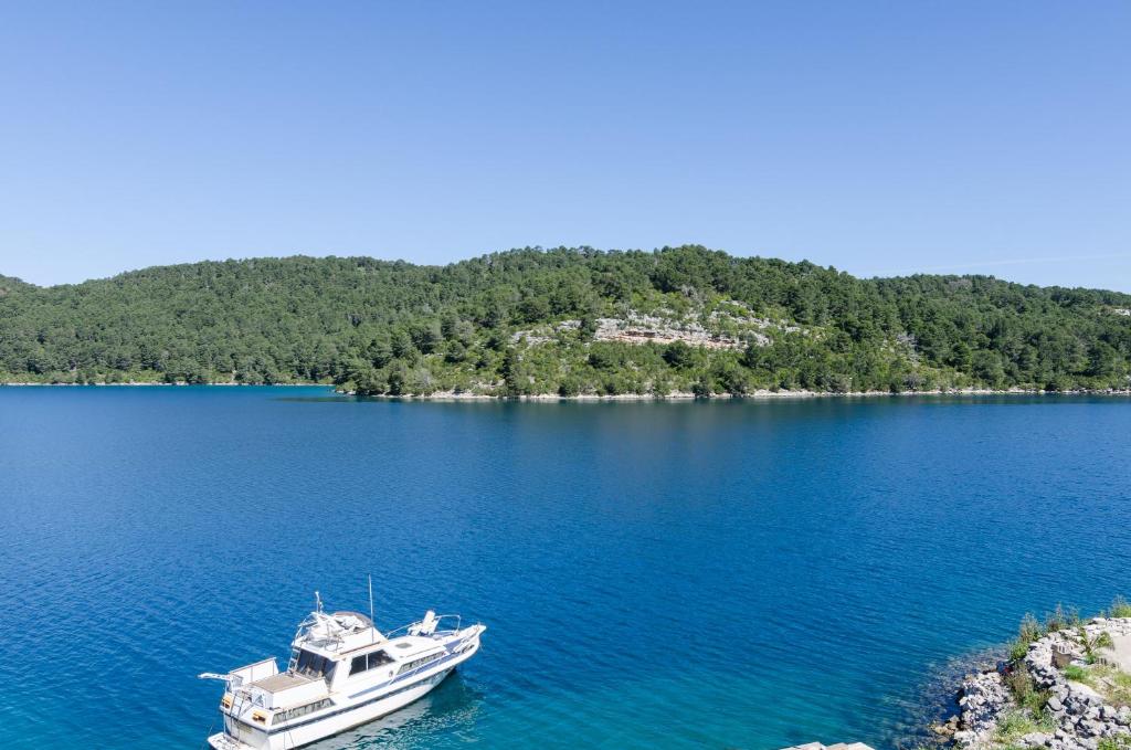 ein weißes Boot mitten in einem großen See in der Unterkunft Apartments Angelo in Polače