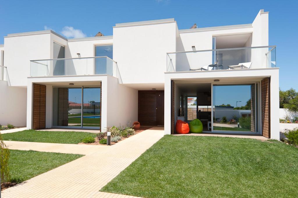 a white house with a lawn in front of it at Seasagres - Design Villas in Sagres