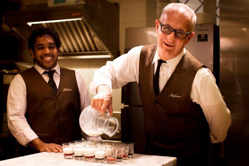 two men standing in a kitchen preparing drinks at Hotel Flora in Venice