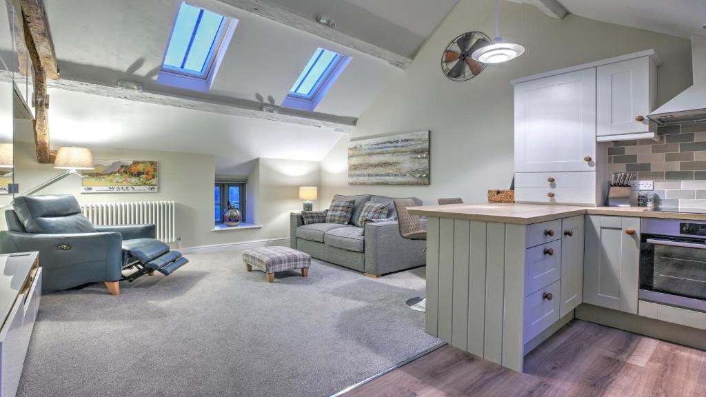 a kitchen and living room with a couch and a table at The Snug - Llyn Peninsula in Pistyll