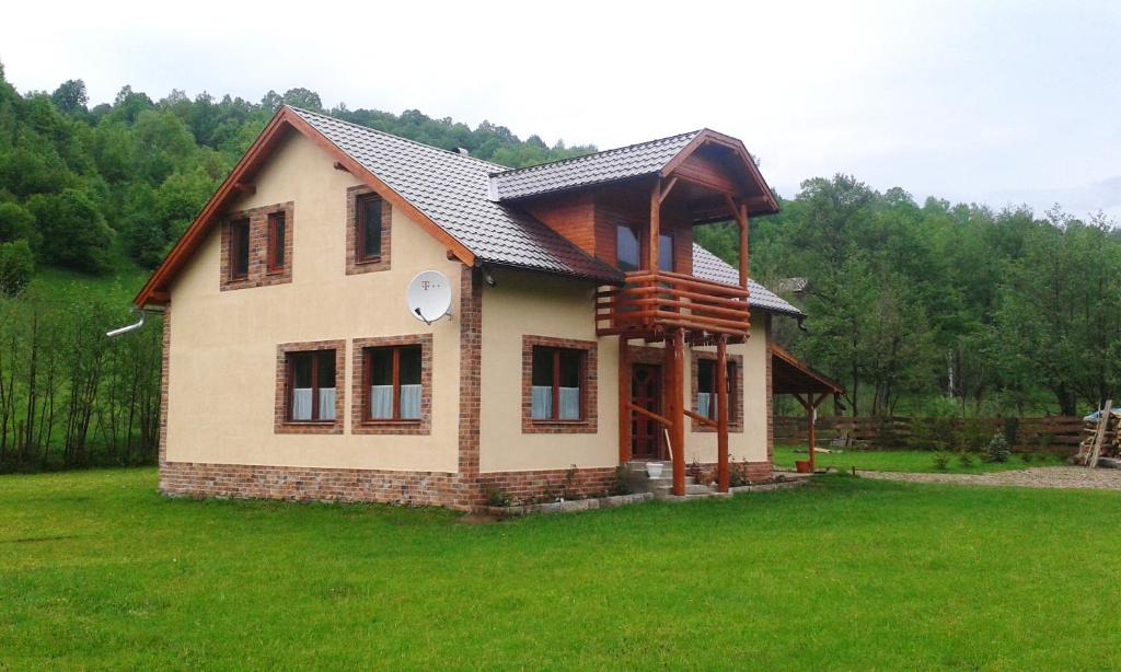 una casa con tetto su un campo verde di Katalin Kulcsosház a Kiruj Fürdő