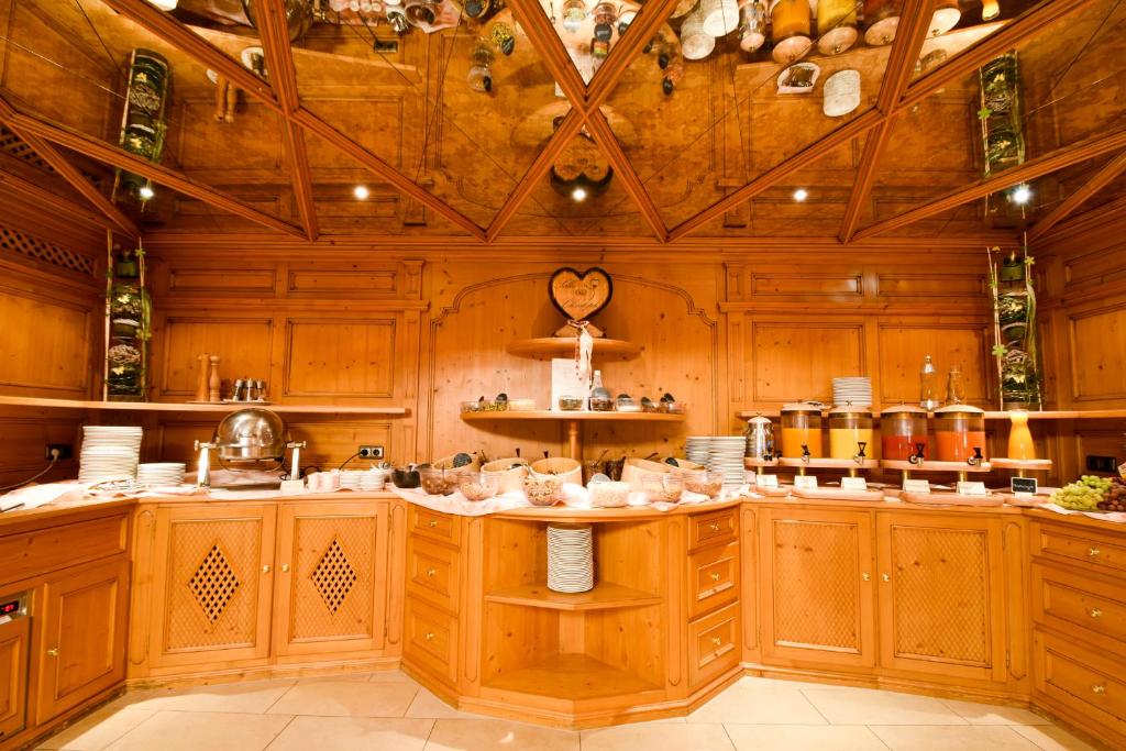 a large kitchen with wooden cabinets and a ceiling at Berg-Spa & Hotel Zamangspitze in Sankt Gallenkirch