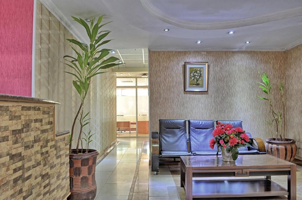 a lobby with a couch and a table with flowers on it at Space International Hotel in Nairobi