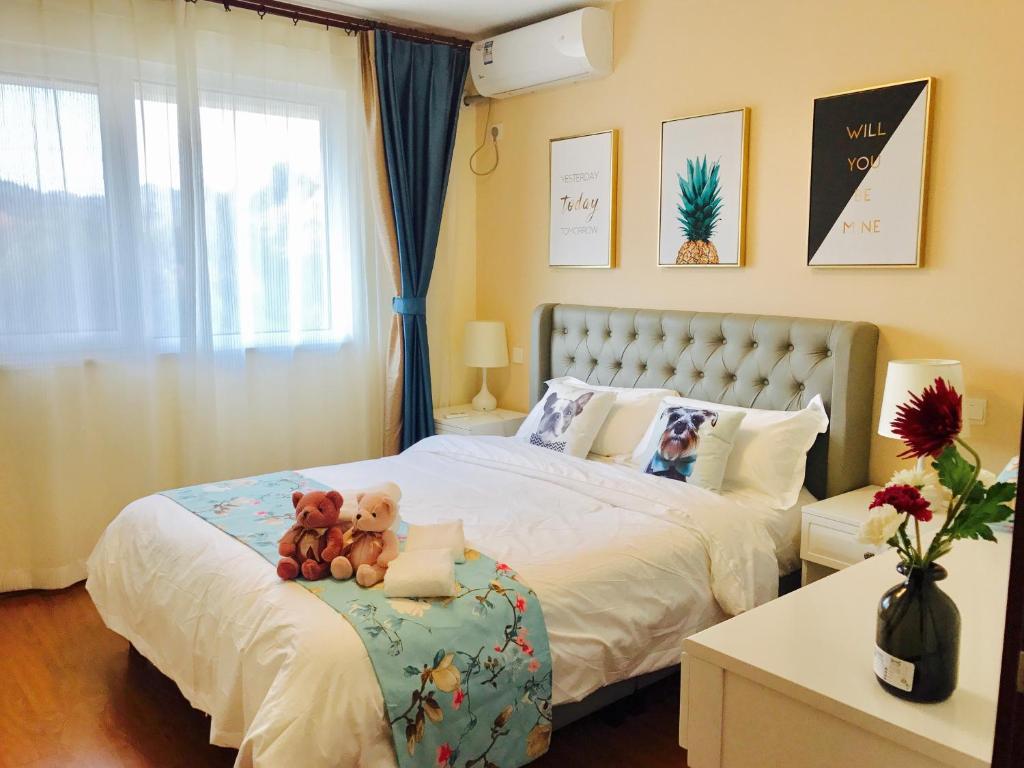 um quarto com uma cama com dois ursinhos de peluche em Beijing Tulu Apartment em Miyun