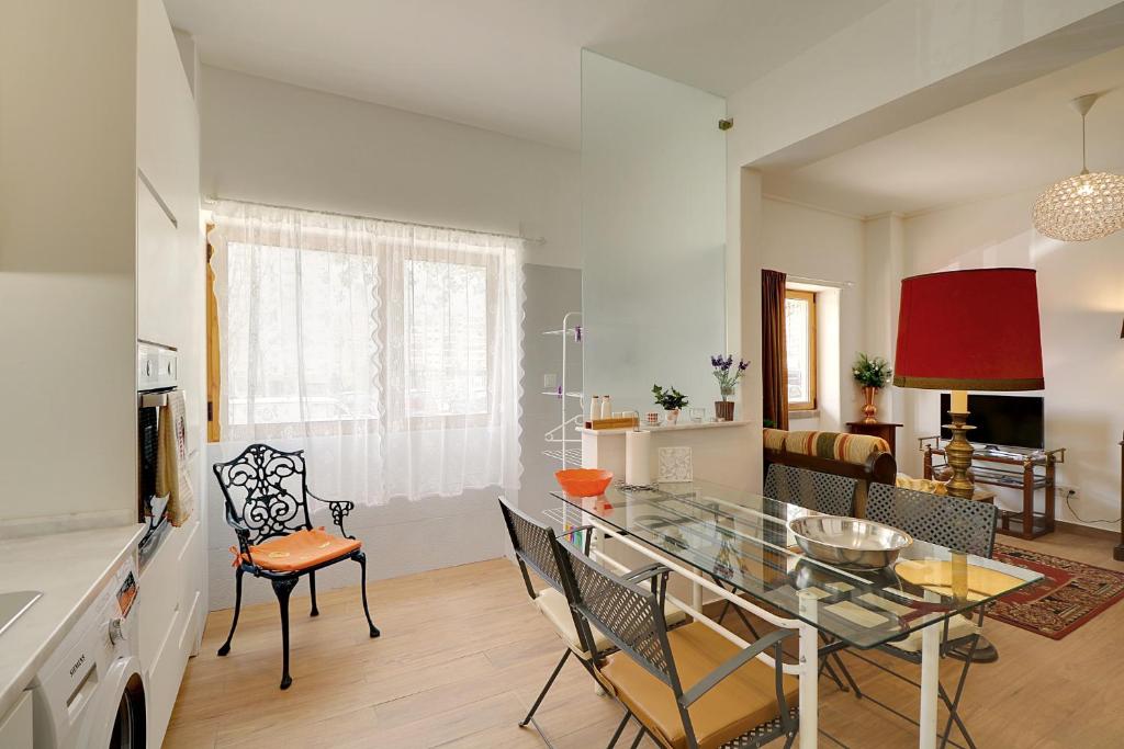 een keuken en eetkamer met een glazen tafel en stoelen bij Casa de Benfica in Lissabon